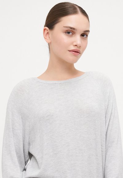 Camisola cinza de mangas compridas com um decote redondo amplo, textura suave e mangas raglan, apresentando um corte descontraído e elementos de design mínimos.