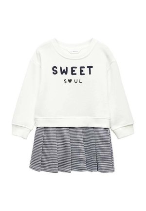 Hvid langærmet top med teksten "SWEET SOUL" og et hjerte, fastgjort til et sort-hvidt ternet plisseret skørt.
