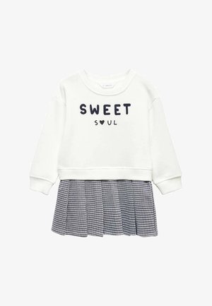 Haut blanc à manches longues avec le texte « SWEET SOUL » et un cœur, attaché à une jupe plissée à carreaux noir et blanc.