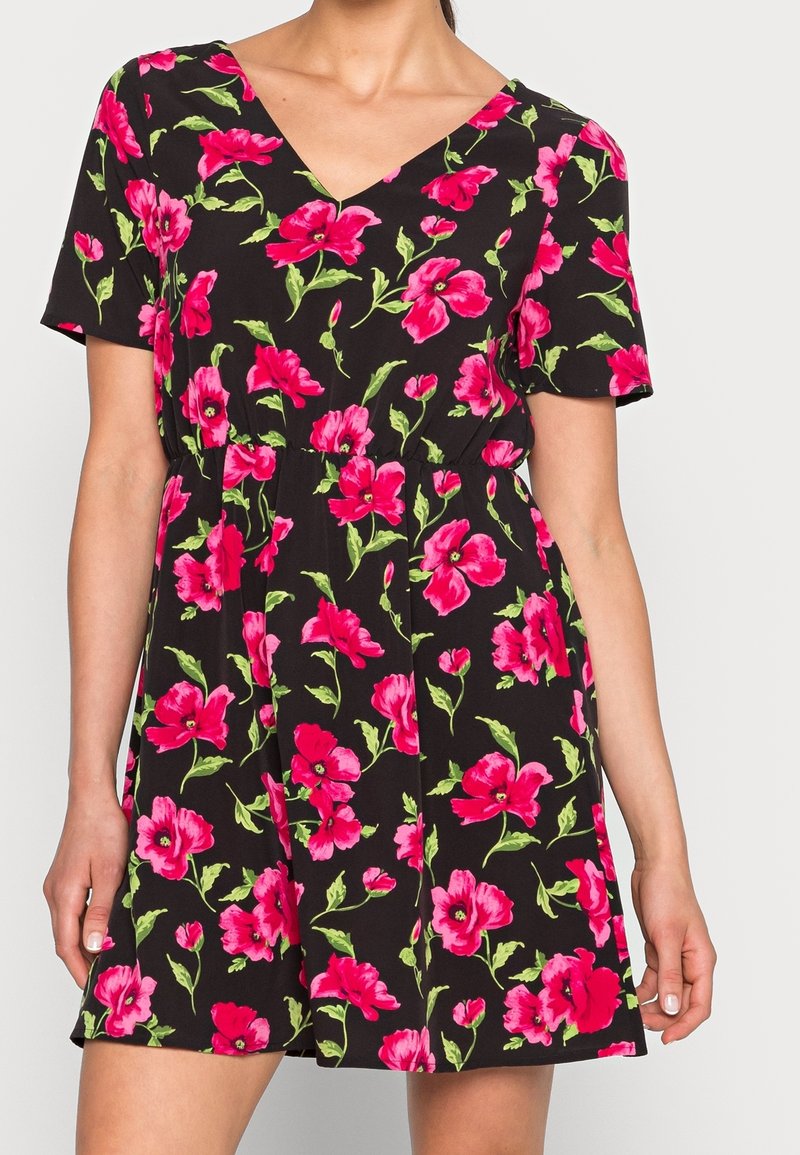Robe noire présentant un motif floral ludique en rose vif et vert. Manches courtes, décolleté en V et taille élastique pour un ajustement parfait.