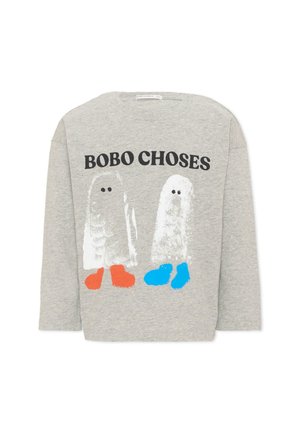 Chemise gris clair à manches longues avec le texte "BOBO CHOSES" au-dessus de deux figures blanches ressemblant à des fantômes portant des chaussures orange vif et bleues.