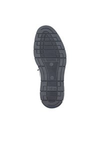 Semelle de chaussure en caoutchouc noir avec des motifs de gorges, comportant des rainures et des crêtes pour la traction, embossée avec le logo "Rieker" au centre.