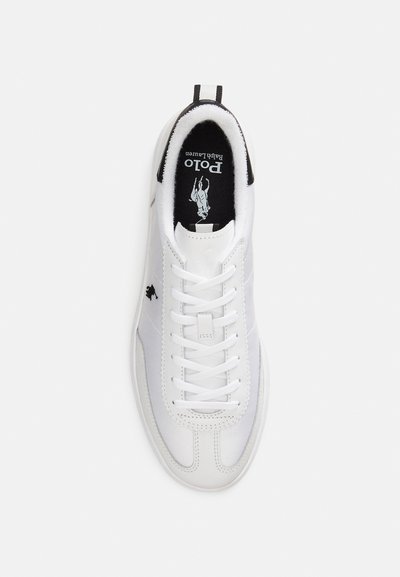White athletic sneaker featuring a smooth leather upper, round toe, and flat laces. Black interior and logo accent on the side.