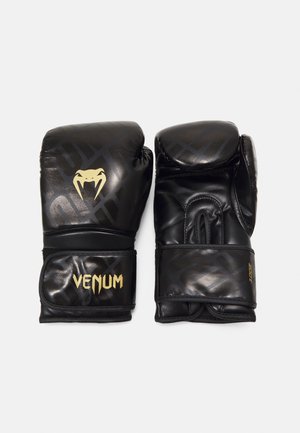 Gants de boxe noirs avec un logo "VENUM" doré et un emblème de serpent. Texture en cuir lisse avec un design rembourré et des sangles réglables au poignet.
