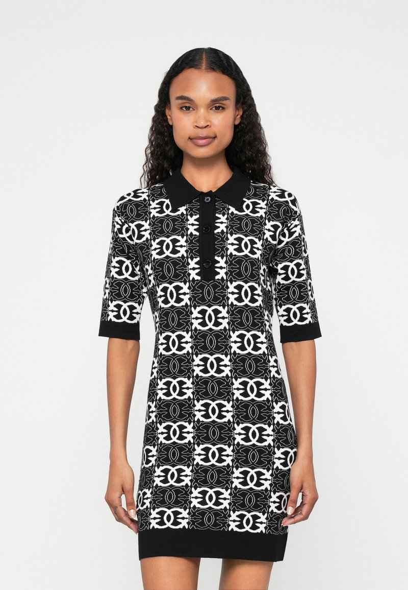 Vestido polo em preto e branco com padrão, com mangas curtas, apresentando colarinho e botões frontais, feito de material de malha texturizada.