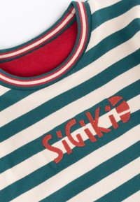 Chemise rayée verte et blanche avec col côtelé rouge et blanc et logo "SiGiKiD" brodé en rouge sur la poitrine.
