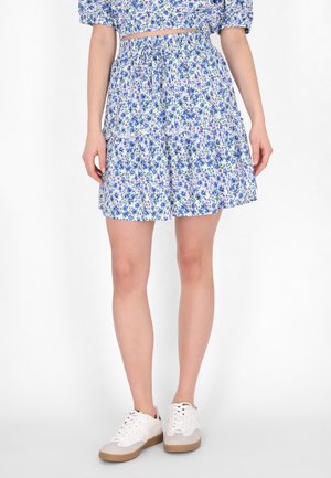 Blomstermønstret nederdel med lagdelt design i blå og hvid, der har elastisk talje og en flæsekant, parret med hvide sneakers.