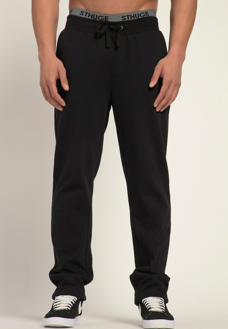 Svarta sweatpants med snörning i midjan, elastiska manschetter vid anklarna och en synlig grå logotyp på midjebandet. Material i bomullsmix.