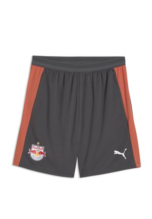 Dunkelgraue Sportshorts mit rostfarbenen seitlichen Einsätzen, Red Bull Salzburg Logo am linken Bein und weißem Puma Logo am rechten Bein.