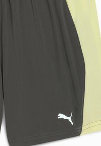 Schwarze und hellgrüne Sportshorts mit strukturiertem Design, mit einem weißen Logo auf der unteren linken Seite. Hergestellt aus feuchtigkeitsableitendem Material.