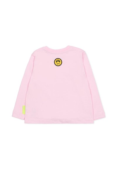 Camicia a maniche lunghe in morbido cotone rosa, con un patch di un volto sorridente nero e giallo sulla schiena e un accento neon verde sul lato.