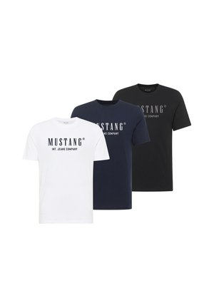 Trzy koszulki z krótkim rękawem i okrągłym dekoltem w kolorach białym, granatowym i czarnym z nadrukiem „MUSTANG INT. JEANS COMPANY” z przodu.