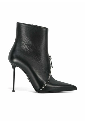 Botte cheville en cuir noir avec un bout pointu, un talon aiguille et un détail de fermeture éclair sur le côté. Texture lisse et design minimaliste.
