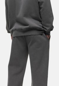 Grijze katoenen sweatshirt en bijpassende broek, met een relaxte pasvorm, ribbelmanchetten en zijzakken, die een zachte textuur laat zien.