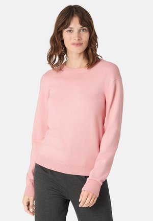 Pull léger rose en tissu doux et texturé ; il présente un col rond, des manches longues et des poignets et un ourlet côtelés.
