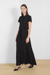 Abito maxi nero con maniche corte, davanti con bottoni e vita legata. Realizzato in tessuto leggero con una texture liscia e una forma fluida.