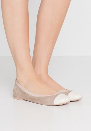 Beżowe baletki zamszowe z błyszczącym kremowym noskiem. Gładka faktura, zaokrąglony kształt i elastyczne wykończenie, ułatwiające zakładanie. Płaskie podeszwy.