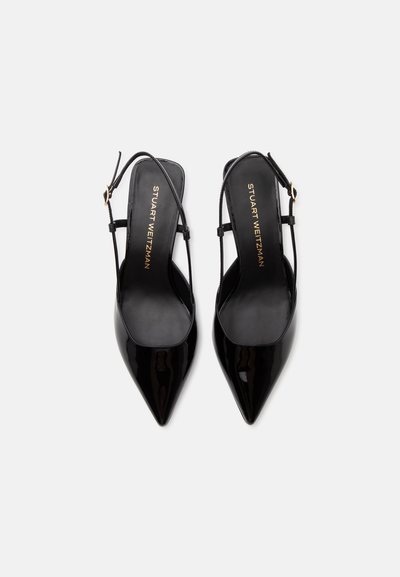 Μαύρες μυτερές γόβες slingback από πατίνα δέρμα με λεπτούς ιμάντες και χρυσά αγκράφες, από πάνω σε λευκό φόντο.