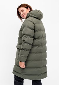 Manteau matelassé vert olive avec capuche, doté d'une taille ceinturée et de poches latérales, présentant une texture matelassée et un design mi-long.