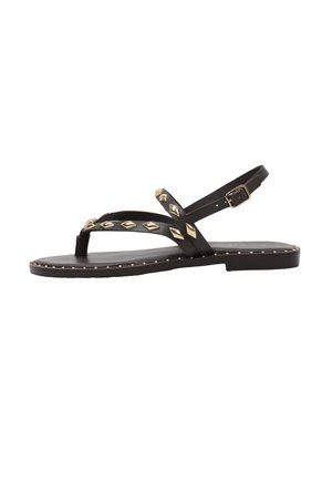 Sandalia plana negra con tachuelas doradas en forma de diamante, diseño con tira en T, hebilla en el tobillo y pequeñas tachuelas doradas a lo largo del borde de la suela.