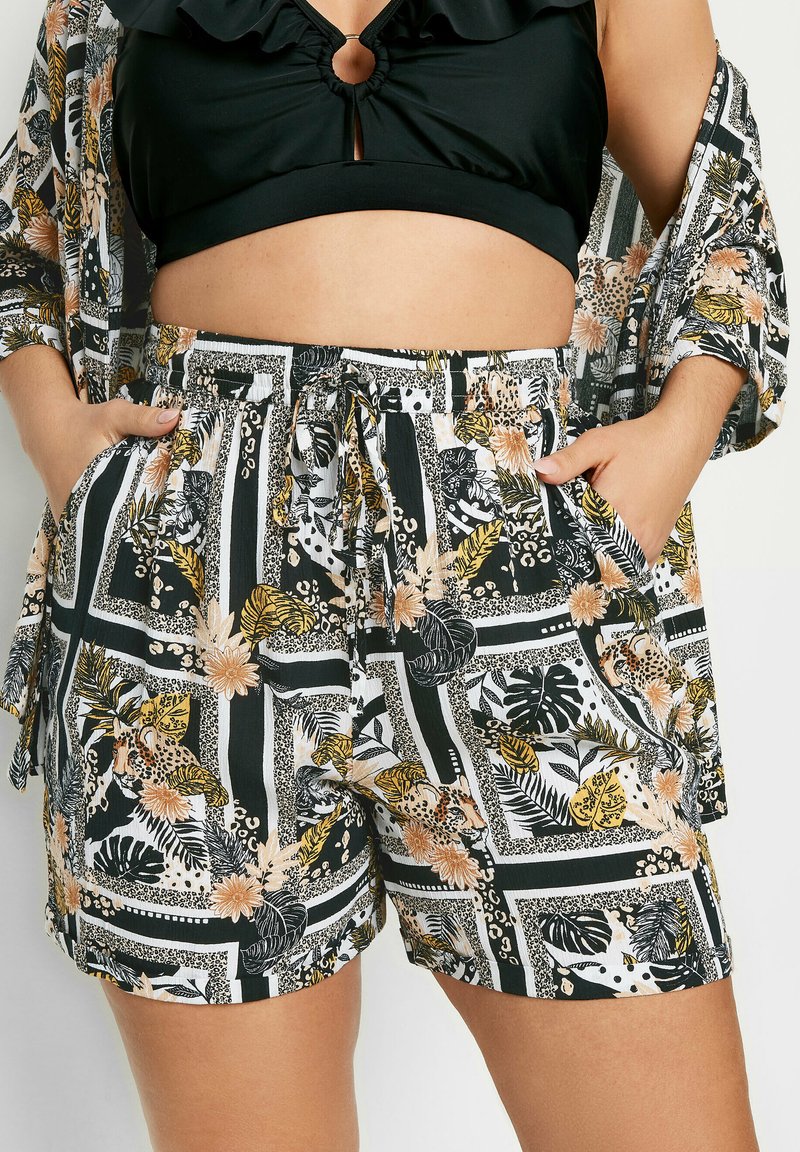 Zwart-witte shorts met een patroon van bloemen en dieren, voorzien van een elastische tailleband en zijzakken, gemaakt van lichtgewicht stof.