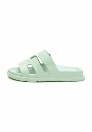 Sandalia de espuma de color verde claro, hecha de material suave, con dos correas anchas con detalles recortados, una suela plana y un diseño minimalista.