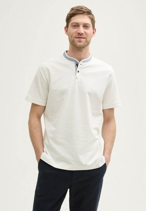Hvid polo shirt med en tekstureret finish, med en blå krave og tre knapper. Enkel design, korte ærmer og afslappet pasform.