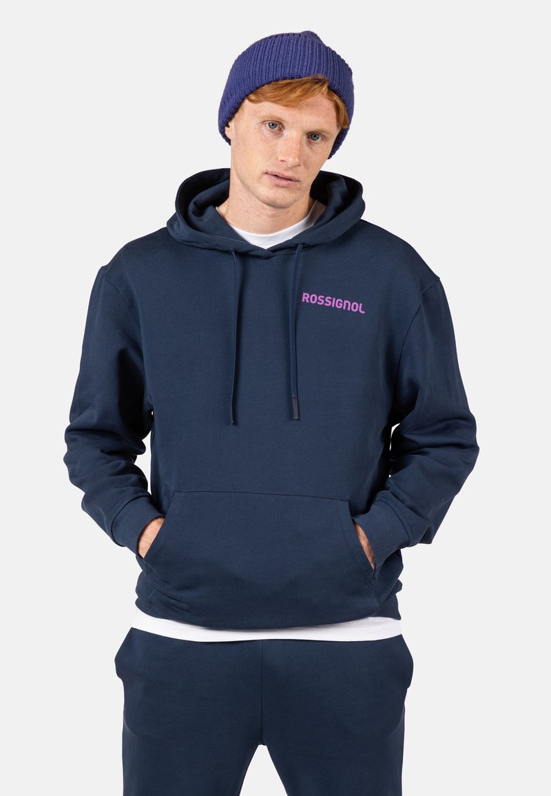 Felpa blu navy realizzata in morbido tessuto, con tasca a canguro, cappuccio regolabile con cordino e logo rosa "ROSSIGNOL" sul petto.