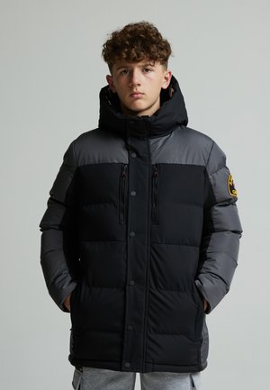 Schwarze und graue Steppjacke mit Kapuze, mit Reißverschlusstaschen und Druckknöpfen. Verfügt über eine glatte Stofftextur und ein Logo-Patch am Ärmel.