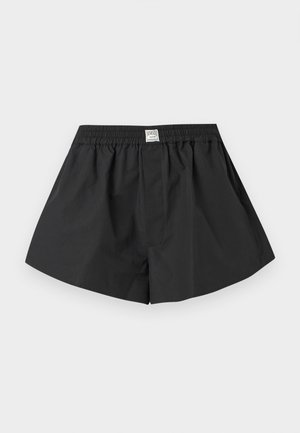 Boxer con elastico in vita nero con una piccola etichetta bianca al centro della cintura, su sfondo bianco semplice.