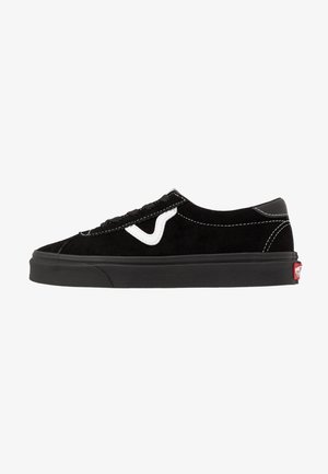 Zapatilla baja de ante negro con raya lateral blanca, cordones negros, suela de goma negra y pestaña con logo rojo en el talón.