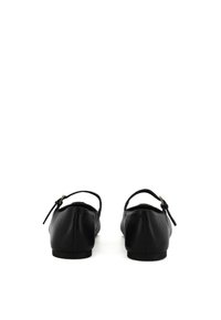 Ballerine di pelle nera con cinturino posteriore, punta arrotondata, texture liscia e design minimalista. Accentuate da un piccolo dettaglio con cinturino.