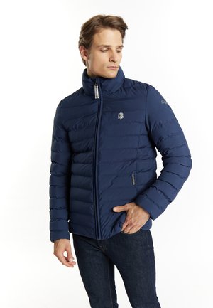 Dunkelblaues Steppjacke mit hohem Kragen, horizontalen Steppnähten, Reißverschluss und Logodetail auf der linken Brust. Warmes und strukturiertes Material.