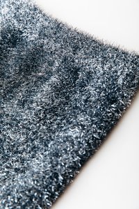 Tessuto argentato metallico con una superficie densa e texture, caratterizzato da corti e soffici filamenti che creano un effetto scintillante.