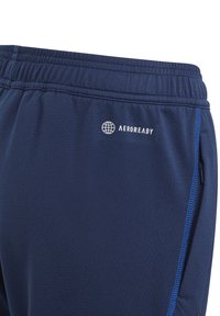 Navy athletic shorts made of smooth fabric, featuring a waistband with elastic, zippered side pockets, and blue accent stitching.