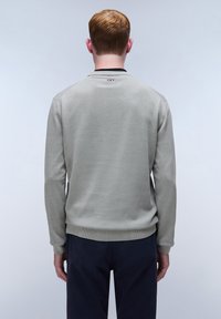 Lichtgrijze trui met lange mouwen, ribbelboorden en zoom, ronde halslijn, en een klein logo aan de achterkant. Glad textuur.