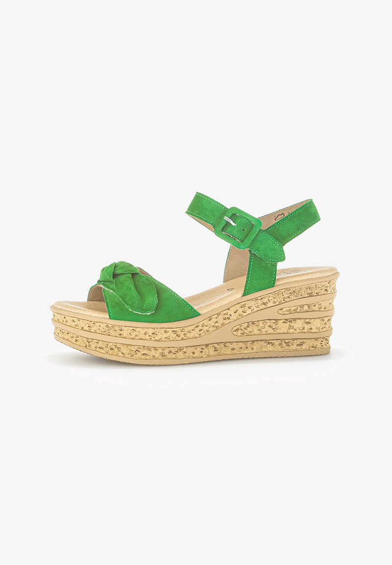 Sandale compensée en daim vert avec bride à boucle à la cheville et semelle plateforme beige texturée, présentant un design noué à l'avant.
