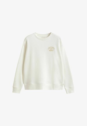 Biała bluza crewneck z długimi rękawami, z małym złotym haftowanym logo "GANT 1949" na lewej piersi.