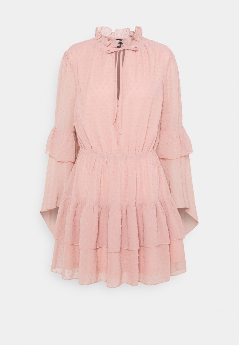 Robe rose clair avec un col à volants et des manches longues. Fabriquée en tissu texturé à motif à pois, elle présente une jupe à volants et un cordon de serrage.