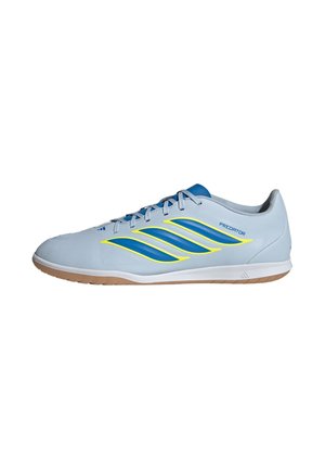 Zapatilla deportiva de perfil bajo azul claro con rayas azules y amarillas, suela de goma, cordones y marca "Predator" en el lateral.