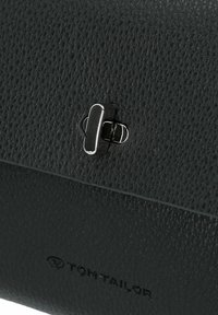 Borsa a tracolla in pelle nera con chiusura a scatto in argento, caratterizzata da una finitura liscia e un logo del marchio impresso sul fondo.