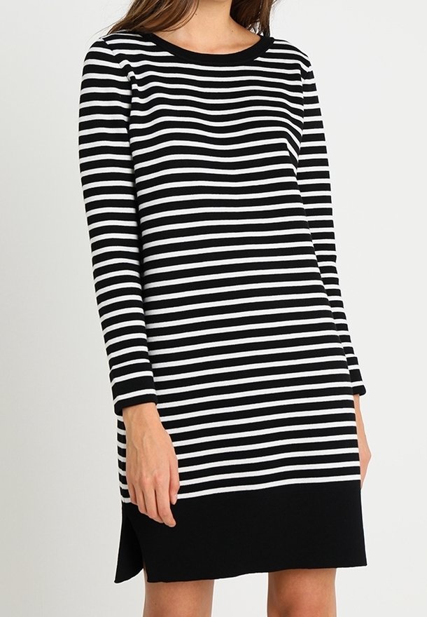Vestido de mangas largas a rayas en blanco y negro con un escote redondeado, que presenta un dobladillo negro sólido y aberturas laterales para mayor comodidad al moverse.
