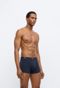 Donkerblauwe boxershorts met een aansluitend ontwerp. Gemaakt van zachte stof, met een zwarte tailleband met het witte "BOSS"-logo.