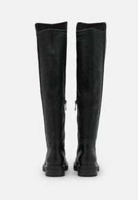 Botas de cuero negro hasta la rodilla con una textura suave, silueta recta, cremallera trasera completa y suela de goma plana.