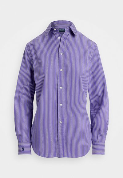 Camisa de manga longa às riscas roxas e brancas com colarinho abotoado, apresentando um pequeno logótipo no punho esquerdo e textura de tecido suave.