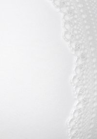 Biely čipkovaný podprsenka s hladkou textúrou látky, ozdobená vlnitým čipkovým lemom a malými dekoratívnymi detailmi pozdĺž okraja.