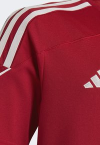 Rotes Sportshirt mit weißen Streifenakzenten an der Schulter. Hergestellt aus Jerseystoff, mit einer leicht strukturierten Oberfläche und Logodetail.