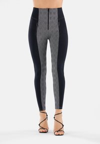 Leggings a vita alta con un motivo a griglia nero e grigio, dotati di tasche con zip e una texture liscia. Completati da una silhouette aderente.