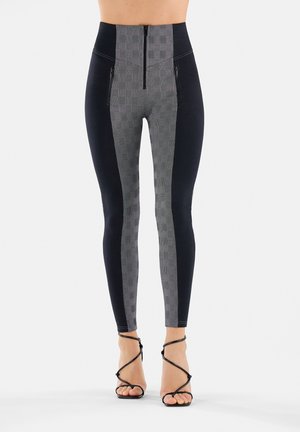 Leggings a vita alta con un motivo a griglia nero e grigio, dotati di tasche con zip e una texture liscia. Completati da una silhouette aderente.