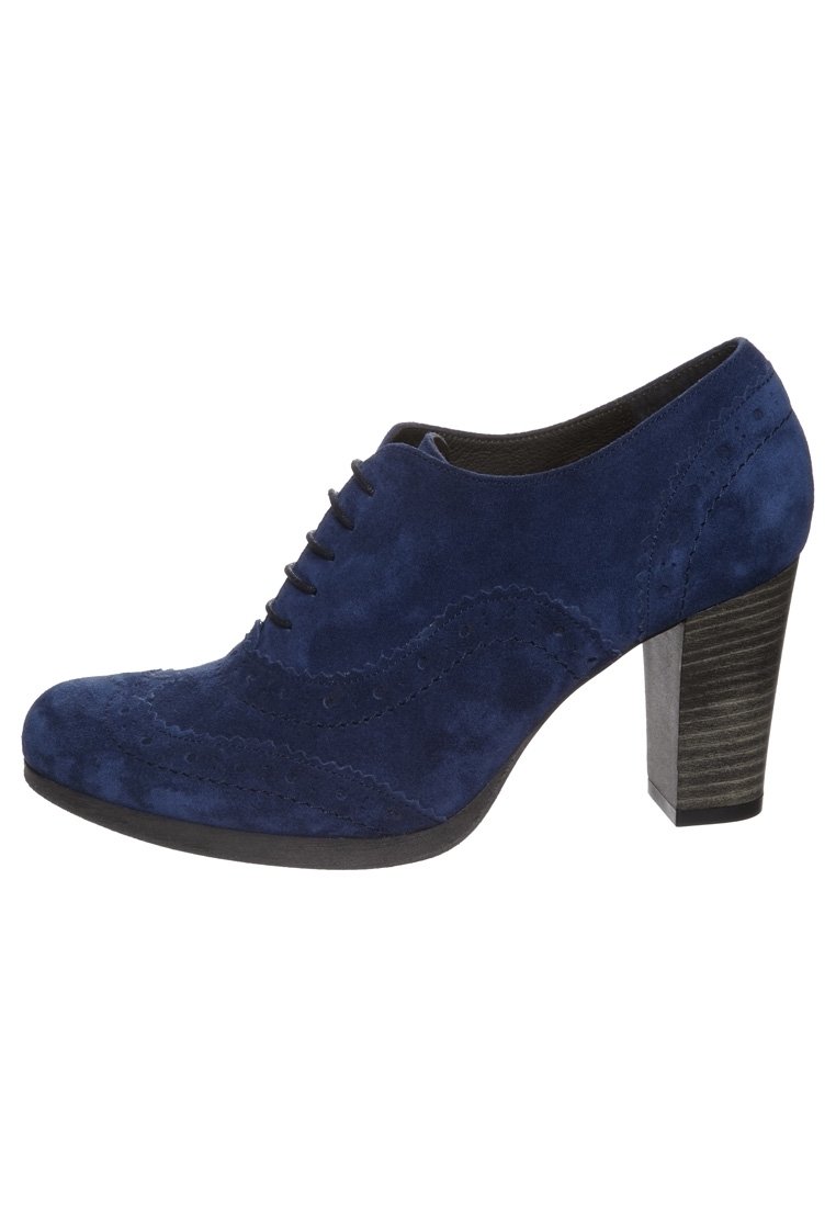 Mörkblå mockaskor med rund tå, snörningsdesign, wingtip-detaljer och en kraftig svart klack med texturerad yta.